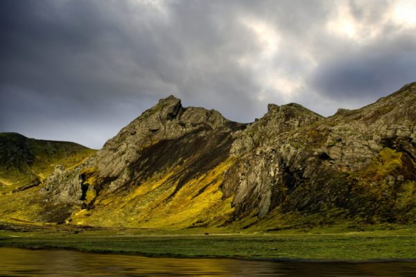 Mountains reflected in water with dramatic sky